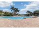 Community pool featuring a spacious deck with ample seating, palm trees and sunny skies at 7001 Interbay Blvd # 219, Tampa, FL 33616