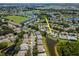 Aerial view of a well-maintained home next to a pond with scenic golf course, and green spaces at 717 Manchester Woods Dr # 717, Sun City Center, FL 33573