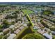 Aerial view showcasing a home near a pond, amidst a community with a golf course and lush green spaces at 717 Manchester Woods Dr # 717, Sun City Center, FL 33573