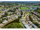 Aerial view of a home next to pond surrounded by lush landscaping, and a community golf course at 717 Manchester Woods Dr # 717, Sun City Center, FL 33573