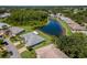 Overhead shot features a backyard pond near lush landscaping and mature trees in a serene neighborhood at 717 Manchester Woods Dr # 717, Sun City Center, FL 33573