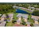 An aerial view displays the home nestled beside a tranquil pond with lush green surroundings and manicured lawns at 717 Manchester Woods Dr # 717, Sun City Center, FL 33573