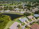 Beautiful aerial showcases lush landscaping and a serene pond, with a well-maintained community visible nearby at 717 Manchester Woods Dr # 717, Sun City Center, FL 33573