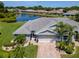 Single-Gathering home overlooking a tranquil pond, complemented by lush landscaping and mature palm trees at 717 Manchester Woods Dr # 717, Sun City Center, FL 33573