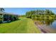 Scenic backyard with lush lawn and tranquil lake view, perfect for relaxation and outdoor enjoyment at 717 Manchester Woods Dr # 717, Sun City Center, FL 33573