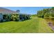 A serene backyard view featuring a well-maintained lawn, tropical plants, and a tranquil pond at 717 Manchester Woods Dr # 717, Sun City Center, FL 33573