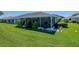 Large backyard featuring green grass, a screened-in lanai, and lush landscaping at 717 Manchester Woods Dr # 717, Sun City Center, FL 33573
