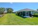 Home's backyard offers a screened lanai, lush lawn, and views of a pond, great for outdoor living at 717 Manchester Woods Dr # 717, Sun City Center, FL 33573