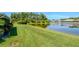 Serene backyard with a well-maintained lawn gently sloping to a peaceful pond view at 717 Manchester Woods Dr # 717, Sun City Center, FL 33573