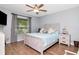 Comfortable bedroom features a decorative ceiling fan, a window overlooking the yard, and wood floors at 717 Manchester Woods Dr # 717, Sun City Center, FL 33573