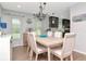 Bright dining room featuring a modern chandelier, wood floors, and an adjacent kitchen area at 717 Manchester Woods Dr # 717, Sun City Center, FL 33573