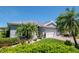 Well-maintained single-Gathering home featuring vibrant landscaping, a brick driveway, and mature palm trees at 717 Manchester Woods Dr # 717, Sun City Center, FL 33573