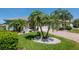 A beautiful single-Gathering home with well-maintained landscaping, a brick driveway, and mature palm trees at 717 Manchester Woods Dr # 717, Sun City Center, FL 33573