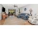 The bright living room is decorated with hardwood floors, ceiling fan and cozy blue couches at 717 Manchester Woods Dr # 717, Sun City Center, FL 33573