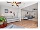 Cozy living room featuring a large window with blinds, hardwood floors, and neutral-toned sofa and sitting chair at 717 Manchester Woods Dr # 717, Sun City Center, FL 33573