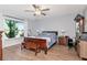 Spacious main bedroom with a ceiling fan, wood floors, and a large window overlooking the backyard at 717 Manchester Woods Dr # 717, Sun City Center, FL 33573
