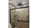 Bathroom features walk-in shower with decorative tile and glass doors at 7321 W Pocahontas Ave, Tampa, FL 33634