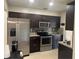 Well-equipped kitchen boasts stainless steel appliances, dark wood cabinets, and granite countertops at 7321 W Pocahontas Ave, Tampa, FL 33634