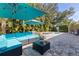 Inviting outdoor patio area with comfortable seating, shade umbrellas, and a rejuvenating hot tub amidst lush landscaping at 8200 31St N Ter, St Petersburg, FL 33710