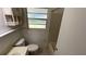 A bathroom featuring a toilet, sink, shower-tub combo and window at 8211 Diagonal N Rd, St Petersburg, FL 33702