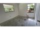 Vacant bedroom featuring concrete floor, two windows and off-white walls at 8211 Diagonal N Rd, St Petersburg, FL 33702
