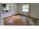 Bedroom with hardwood and missing flooring and two bright windows at 8211 Diagonal N Rd, St Petersburg, FL 33702