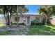 Charming single-story home with light gray siding, pink shutters, and a well-manicured front yard at 8211 Diagonal N Rd, St Petersburg, FL 33702
