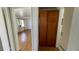 Hallway view with a large wooden closet and a view into a sunny, vacant living room at 8211 Diagonal N Rd, St Petersburg, FL 33702
