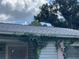 Close-up of the roof, showcasing the shingle texture, with some climbing vegetation at 8211 Diagonal N Rd, St Petersburg, FL 33702