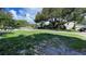 Serene street view with a green lawn and scattered trees that surround a house at 8211 Diagonal N Rd, St Petersburg, FL 33702