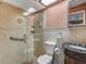 Bathroom with tile shower stall, glass doors, vanity with granite countertop, toilet, and bright skylight at 8336 Monaco Dr # A, Port Richey, FL 34668