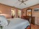 Bedroom has a wrought iron bed frame, hardwood floors, and a wooden dresser next to a bathroom and walk-in closet at 8336 Monaco Dr # A, Port Richey, FL 34668