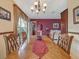Dining room with large wooden table, ornate chairs, chandelier, and bright natural light from the large windows at 8336 Monaco Dr # A, Port Richey, FL 34668
