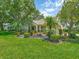 Attractive home with a lush front yard, a variety of trees and plants, and a tranquil water fountain at 8336 Monaco Dr # A, Port Richey, FL 34668