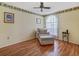 Cozy living room features a comfy chair with ottoman, hardwood floors, and a bright window at 8336 Monaco Dr # A, Port Richey, FL 34668
