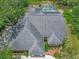 Aerial view showcases a private pool with screened enclosure, solar panels, and lush landscaping enhancing outdoor living at 8711 Crescent Forest Blvd, New Port Richey, FL 34654