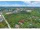 Aerial view of the property with mature trees and a nearby lake on Little Rd at 8711 Crescent Forest Blvd, New Port Richey, FL 34654