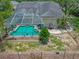 Aerial view showcases a private pool with screened enclosure, solar panels, and lush landscaping enhancing outdoor living at 8711 Crescent Forest Blvd, New Port Richey, FL 34654