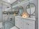Bathroom featuring double vanity, a glass enclosed shower, and modern lighting at 8711 Crescent Forest Blvd, New Port Richey, FL 34654