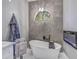 Bathroom with a standalone soaking tub, gray tiling, and decorative lighting at 8711 Crescent Forest Blvd, New Port Richey, FL 34654