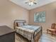 Cozy bedroom with a full-size bed, neutral walls, wood-look floors, and a bright window at 8711 Crescent Forest Blvd, New Port Richey, FL 34654