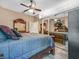 Bedroom features hardwood floors, a ceiling fan, and a large mirror that makes the room feel more spacious at 8711 Crescent Forest Blvd, New Port Richey, FL 34654
