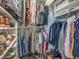 Walk-in closet displaying clothing on hangers, folded on shelves, and shoes at 8711 Crescent Forest Blvd, New Port Richey, FL 34654