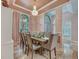 Elegant dining room boasting a chandelier, decorative ceiling trim, and large windows with natural light at 8711 Crescent Forest Blvd, New Port Richey, FL 34654