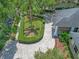 Aerial view showcasing a circular driveway, lush landscaping, and a charming brick mailbox enhancing curb appeal at 8711 Crescent Forest Blvd, New Port Richey, FL 34654
