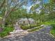 Charming home with meticulously maintained landscaping, a circular driveway, and mature trees, providing a serene and picturesque setting at 8711 Crescent Forest Blvd, New Port Richey, FL 34654