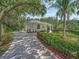 Beautiful home exterior with manicured landscaping, a paved driveway, and lush green surroundings at 8711 Crescent Forest Blvd, New Port Richey, FL 34654