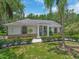Beautiful single-story home featuring well-manicured landscaping and an inviting entrance with stately columns and a brick facade at 8711 Crescent Forest Blvd, New Port Richey, FL 34654