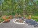 Cozy backyard fire pit with Adirondack chairs and a peaceful forest setting at 8711 Crescent Forest Blvd, New Port Richey, FL 34654