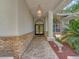 Inviting front entrance with brick accents, decorative lighting, and meticulously maintained landscaping at 8711 Crescent Forest Blvd, New Port Richey, FL 34654
